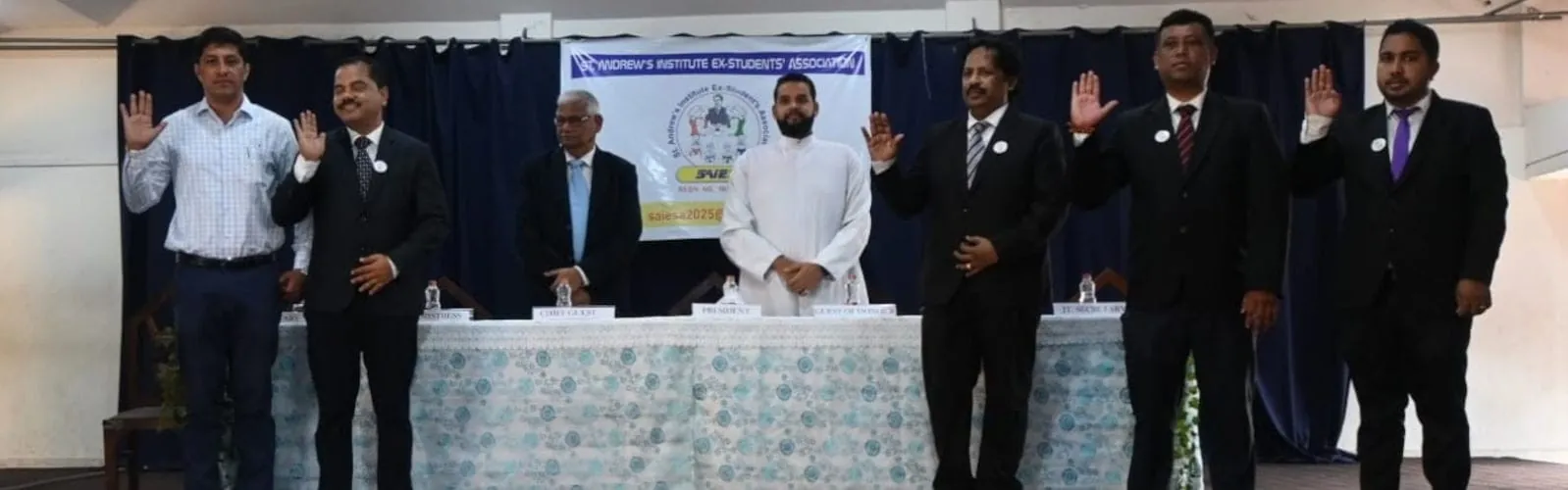 SAIESA's managing committee members standing together, hands raised, taking their oath of office